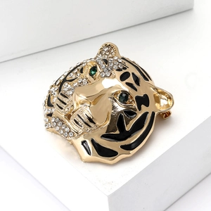 Vintage gold tiger head brooch with white rhinestones and green emerald eyes
