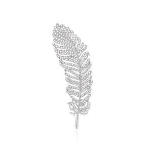 Sparkling silver leaf feather brooch with rhinestones on a white reflective background