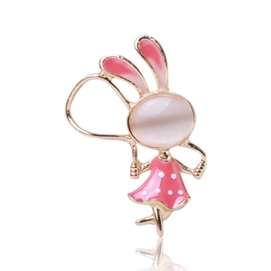 Détail d'une broche lapin dorée avec pierre opale et robe rose à pois blancs