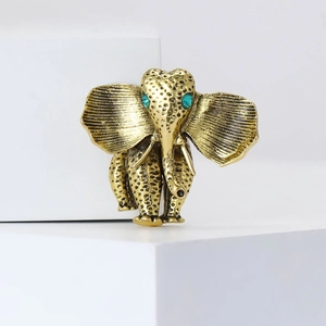 Vintage elephant brooch in antique gold finish with turquoise gem eyes and textured alloy