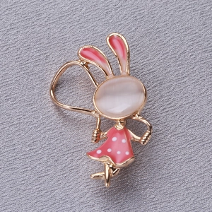 Vue macro de la broche lapin mignon avec base dorée et robe à pois sur tissu