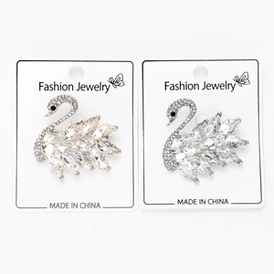Detailed view of elegant gold and silver swan brooches with sparkling crystal rhinestones