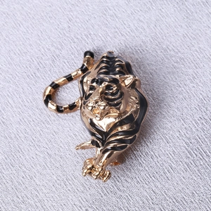 Macro shot of tiger brooch detail showing gold-plated alloy and black enamel finish