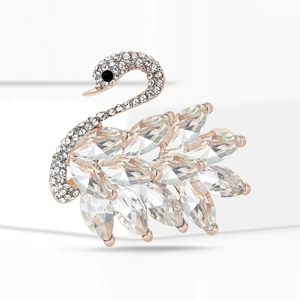 Detailed view of swan brooch featuring rose gold plating and crystal wing embellishments