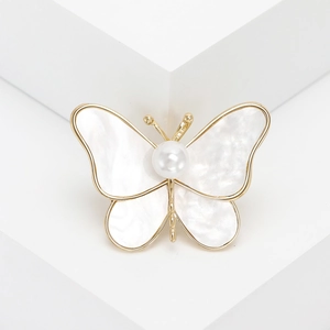 Elegant gold butterfly brooch with white mother-of-pearl inlay and a central pearl accent