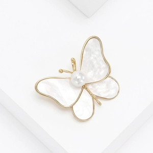 Elegant gold butterfly brooch with shimmering mother-of-pearl wings and central pearl