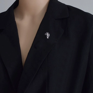 Elegant silver leopard brooch with black spots pinned on a black suit lapel