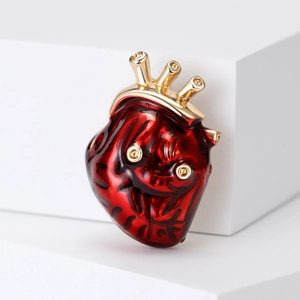 Broche cœur anatomique artistique en émail rouge et métal doré sur socle blanc