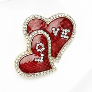 Detail of red heart brooch with crystal rhinestones and LOVE lettering in enamel finish