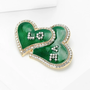 Detail of emerald enamel double heart brooch with sparkling crystals and LOVE lettering