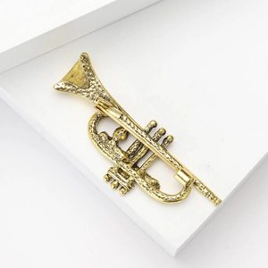 Detailed view of vintage gold alloy trumpet brooch showing textured finish and pin back