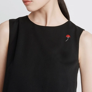 Élégante broche en feuille de ginkgo rouge avec cristaux sur une tenue noire sans manches