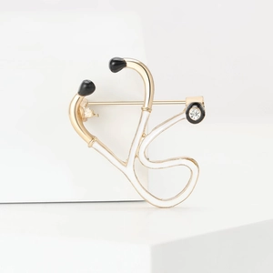 Creative alloy stethoscope brooch with gold plating and white enamel detailing