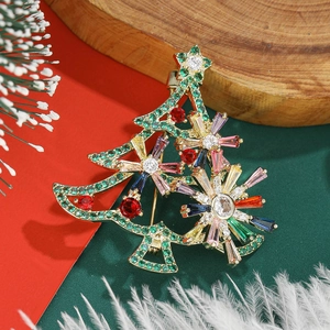 Macro shot of a Christmas tree brooch with colorful zircons and golden metal base