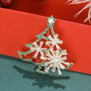Close-up of golden Christmas tree brooch with green, red and clear sparkling crystals