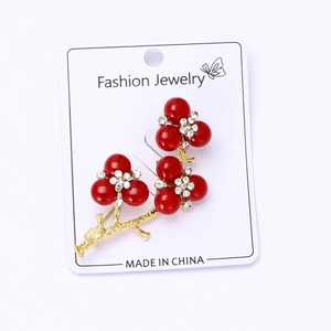 Detailed macro view of the golden flower branch brooch with red beads and tiny diamonds