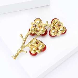 Elegant gold tree branch brooch with red beads and luxury pin back on white stand