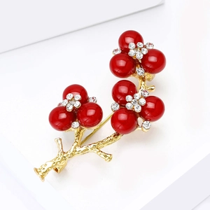 Elegant gold branch brooch with red berry clusters and sparkling white crystals