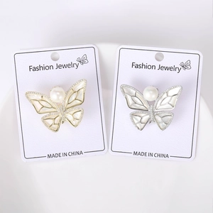 Macro detail of gold and silver butterfly brooches with mother-of-pearl and pearls