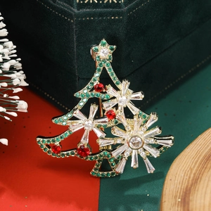 Close-up of rotatable Christmas tree brooch with green zircons and snowflake details