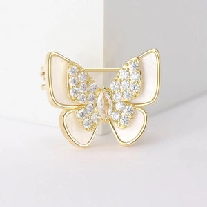 Detaillierte Makroaufnahme einer goldenen Schmetterlingsbrosche mit Perlmutt und Zirkonia