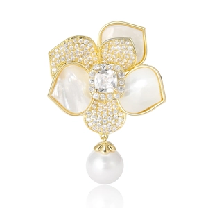 Élégante broche camélia dorée avec pétales en nacre, zircons et une perle pendante