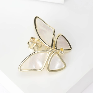 Elegant gold-plated butterfly brooch with iridescent mother of pearl wings on white background