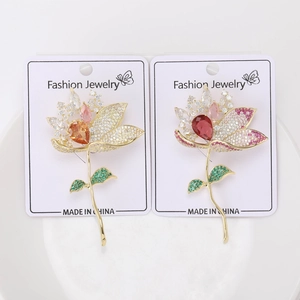 Détail des broches fleur de lotus en zircons dégradés présentées sur carte de support