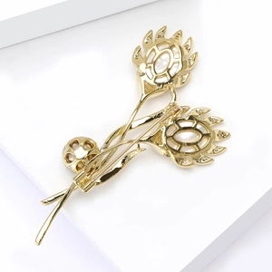 Broche tulipe dorée élégante avec nacre et zircons sur plateforme blanche