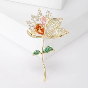 Broche lotus dorée élégante avec zircons dégradés sur un support blanc minimaliste