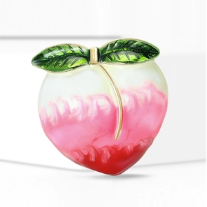 Détail de la broche pêche avec émail dégradé rose et feuilles vertes sur métal doré