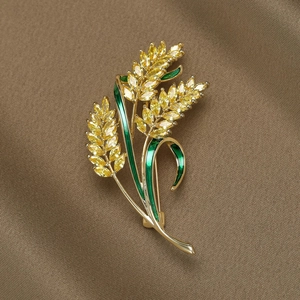 Golden wheat ear brooch with yellow zircons and green enamel on brown silk background