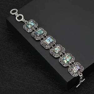 Vintage hollow filigree bracelet with iridescent abalone shell inlays and toggle clasp