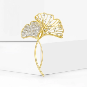 Detailed view of a gold ginkgo leaf brooch with micro-pave white cubic zirconia accents