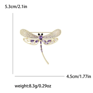Detailed view of luxury dragonfly brooch with purple gems and micro-pave cubic zirconia