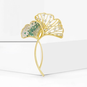 Detail view of a ginkgo leaf brooch featuring green zircon micro-inlay on gold plating