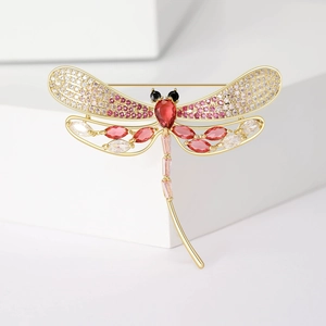 Elegant gold dragonfly brooch with pink crystals and large red teardrop gemstone