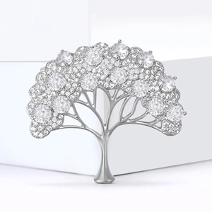 Broche arbre argentée exquise avec des oxydes de zirconium sur un socle blanc