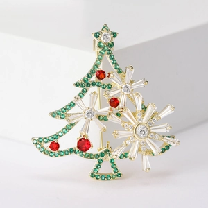 Detail of Christmas tree brooch with green and red zircons on a white geometric stage