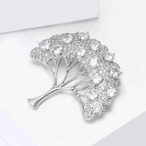 Détail d'une broche arbre en argent avec zircons blancs étincelants et design ajouré chic