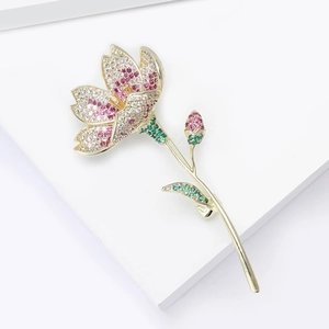 Detailaufnahme einer Blumenbrosche in Gold mit rosa, weißen und grünen Zirkoniasteinen
