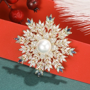 Macro detail of snowflake brooch with pearls and zircon crystals on festive red gift box