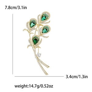 Elegant gold peacock feather brooch with green crystals and small white diamonds
