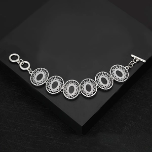 Detail of silver hollow oval links bracelet with decorative mesh texture and toggle clasp