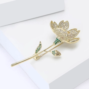 Nahaufnahme der eleganten Blumenbrosche mit weißen Zirkonia und grünen Edelsteinakzenten