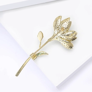 Detailansicht der Rückseite einer goldenen Blumenbrosche mit Anstecknadel und Textur