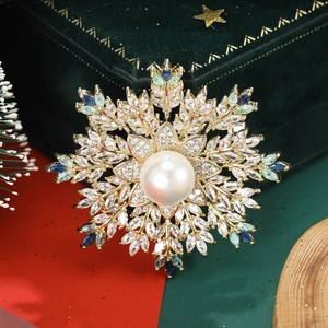 Close-up of snowflake brooch with a large central pearl and multicolored gemstones