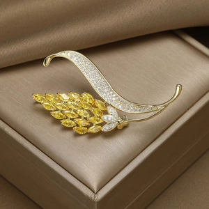 Détail de l'élégante broche en épi de blé avec placage d'or et zircon brillant