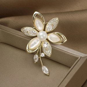 Broche fleur dorée élégante avec pétales en nacre et perle centrale sur soie brune