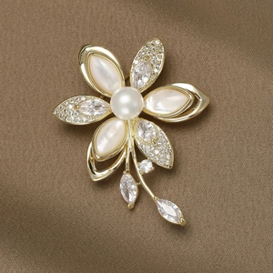 Broche camélia élégante en nacre blanche avec pétales dorés et grande perle centrale